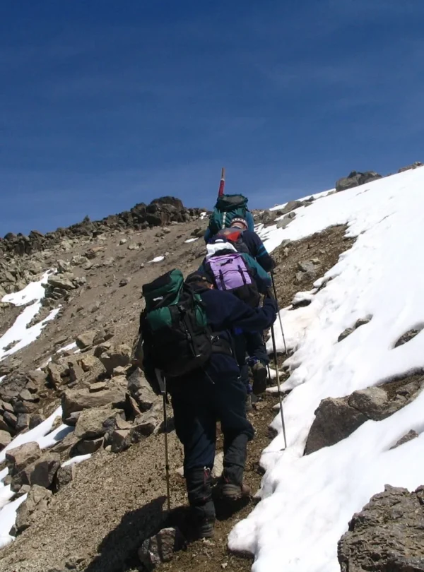 A group of hikers ascend the high, loose gravel slopes on Mount Kenya.